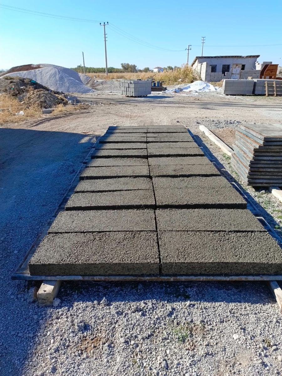 Sahamızda palet üstünde iki sıra dizilmiş beton mezar kapakları
